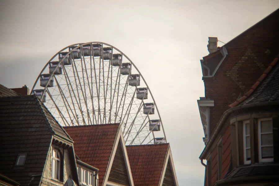 Ein Riesenrad ragt im Gegenlicht über die Dächer der Altstadt