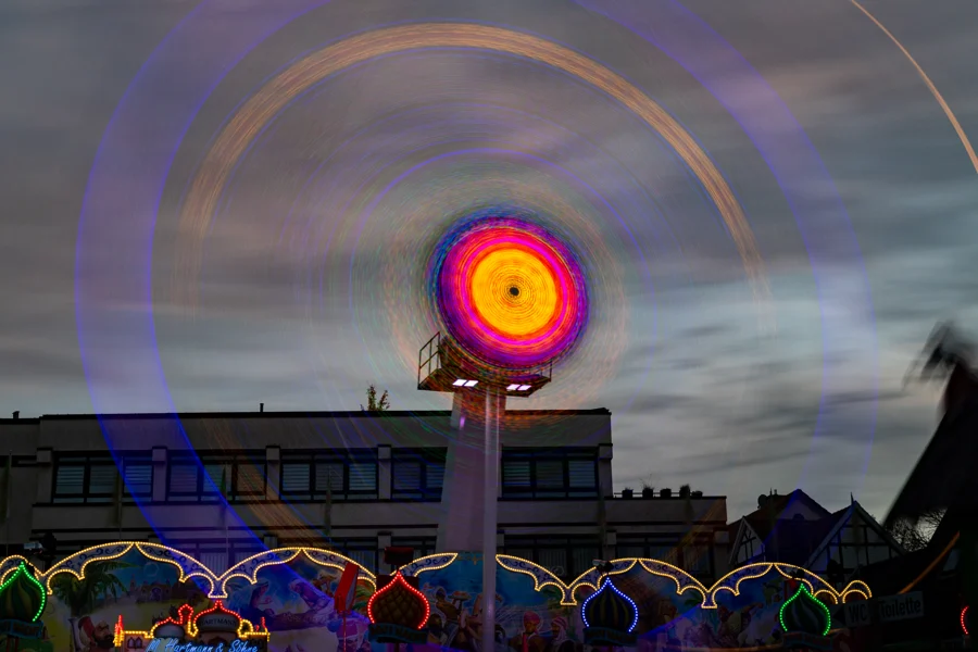 Gelbe und violette Lichtspuren eines Fahrgeschäfts