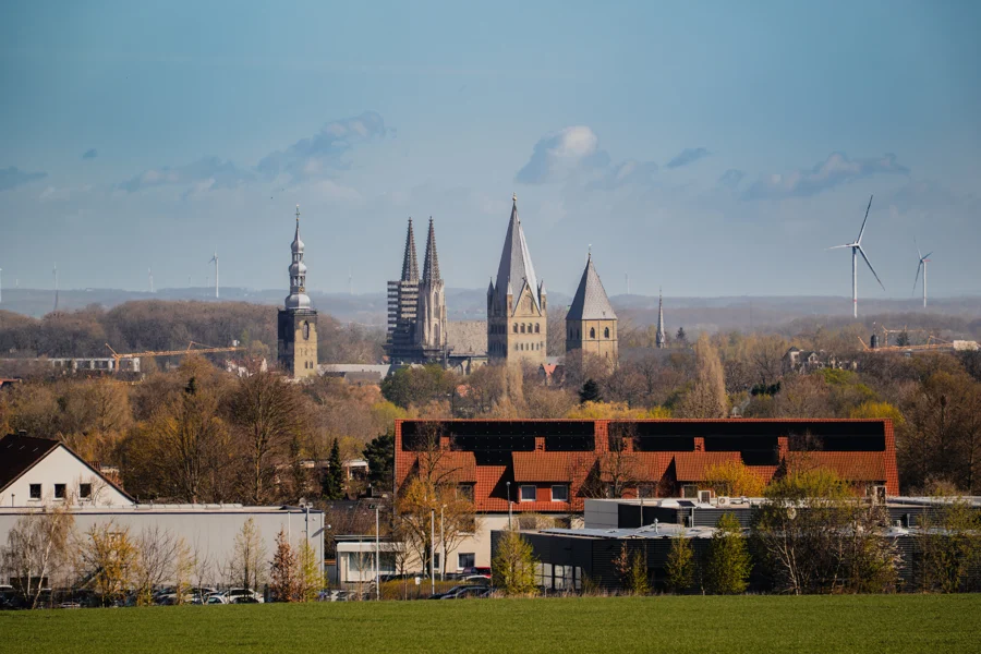 Kirchtürme und Dächer zwischen Feldern und Bäumen
