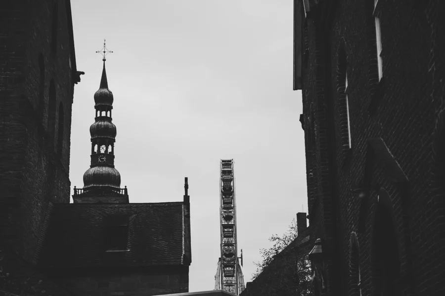 Schwarzweiße Kirchtürme zwischen dunklen Gebäudekanten