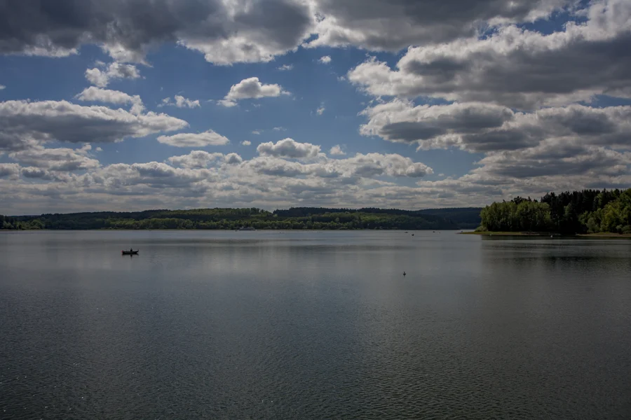 Ruhiger See unter einem weiten Himmel mit kleinen Wolken