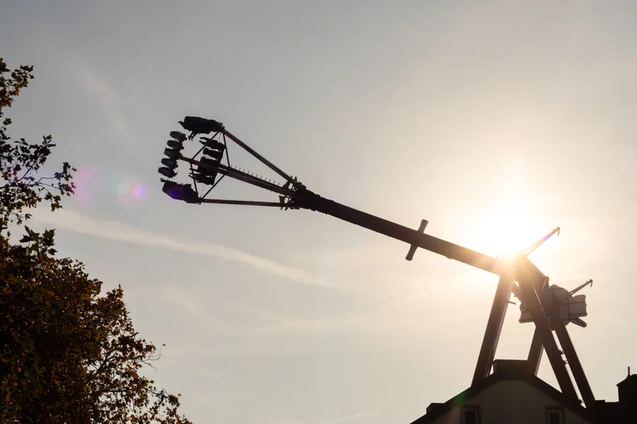 Silhouette eines Fahrgeschäfts im Gegenlicht auf der Kirmes