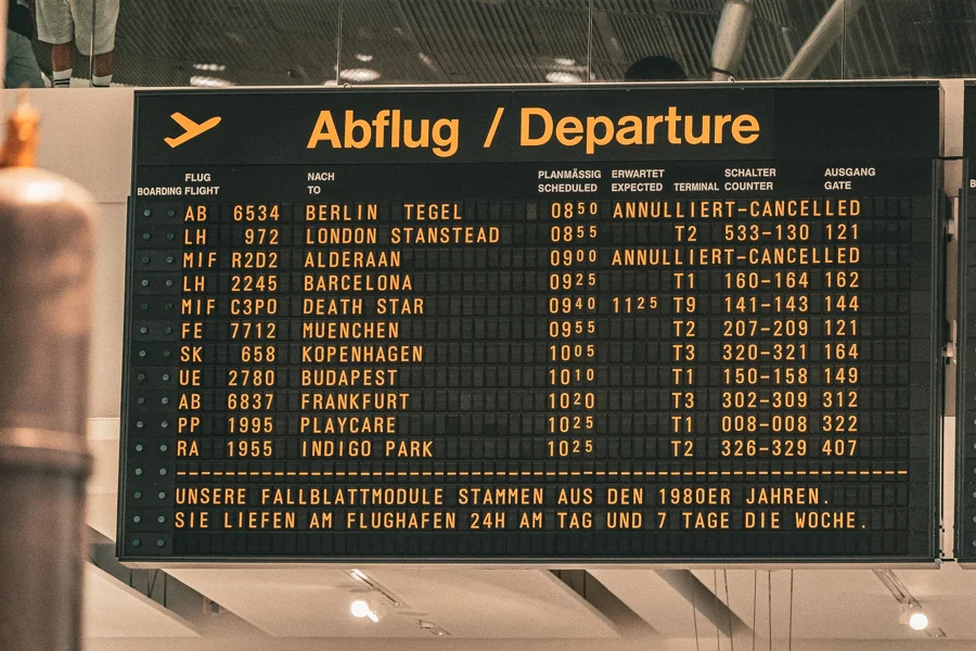 Abflugtafel mit gelber Schrift vor dunklem Hintergrund