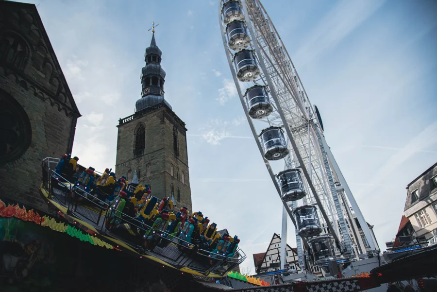 Fahrgeschäfte und historische Gebäude auf der Soester Kirmes