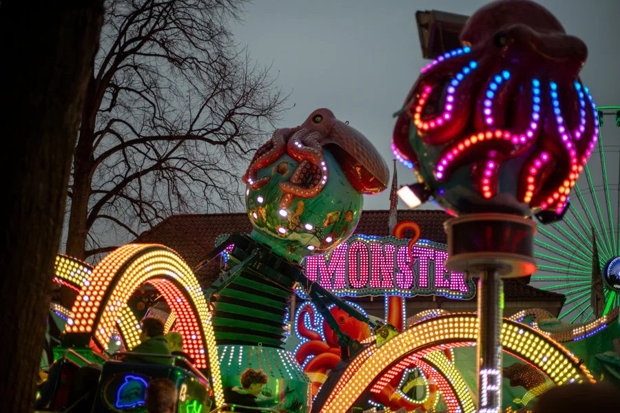 Bunte Figuren und Lichtreklame am Fahrgeschäft Big Monster